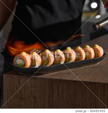 Restaurant Chef cook preparing salmon filet flambe in open kitchen Restaurant Chef cook preparing salmon filet flambe in open kitchen 89485495