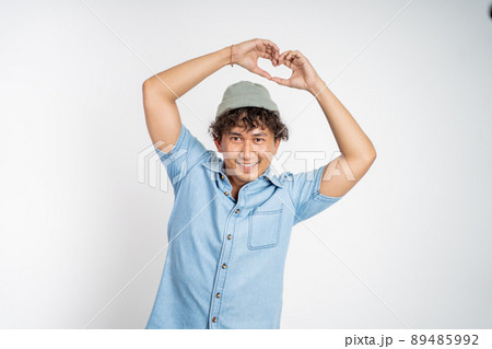 man forming a heart with finger gestures on isolated background 89485992
