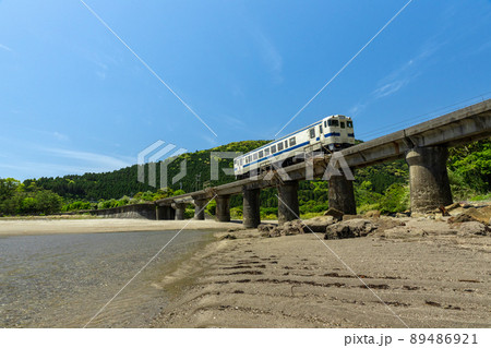 日南海岸の快晴で青空が広がる宮崎県日南市山王の隈谷川橋梁を走るJR九州ローカル線日南線キハ40 89486921