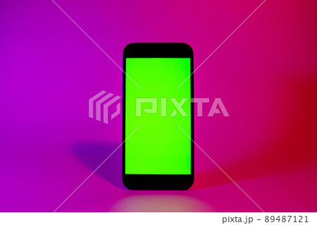 Mobile phone with green screen, smartphone mock up. Neon illumination. Pink and purple color. Flat screen modern smartphone Mobile phone with green screen, smartphone mock up. Neon illumination. Pink and purple color. Flat screen modern smartphone 89487121