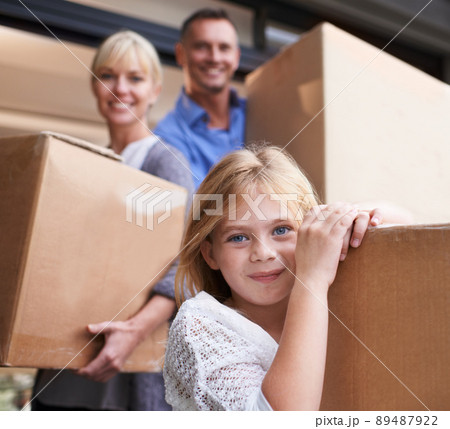 Were going to our new house. A family of three carrying boxes into their new home. 89487922