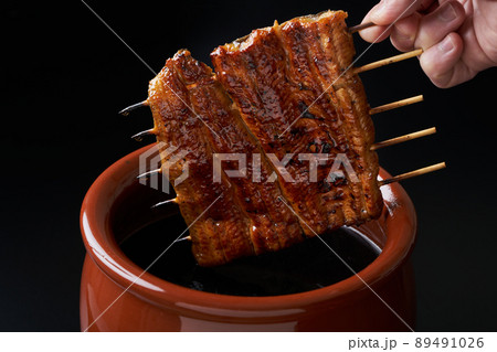 鰻の蒲焼をタレに漬ける 鰻の蒲焼をタレに漬ける 89491026