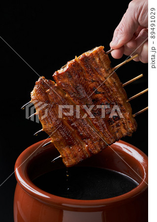 鰻の蒲焼をタレに漬ける 鰻の蒲焼をタレに漬ける 89491029