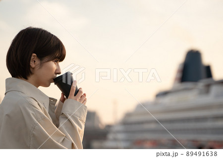 屋外でコーヒーを飲みながらくつろぐ女性 89491638