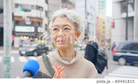 街頭インタビューを受けるシニア女性 街頭インタビューを受けるシニア女性 89491815