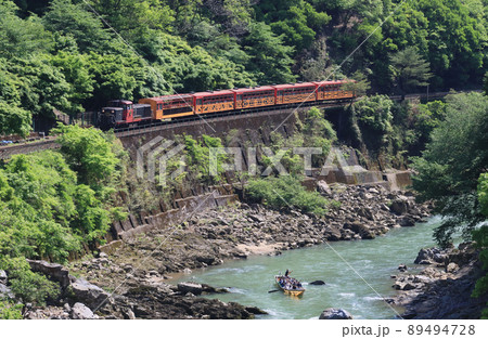 新緑の保津峡を走るトロッコ列車 89494728