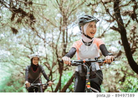 Happiness of beautiful young muslim woman wearing sportswear while cycling Happiness of beautiful young muslim woman wearing sportswear while cycling 89497589