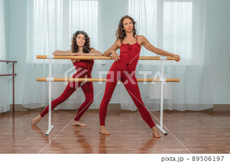 I train with a friend. Two young women train together in a bright training room near a choreographic machine. 89506197