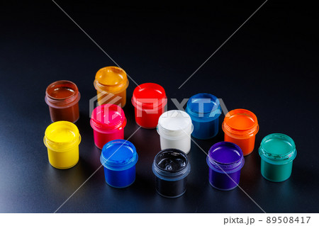close-up background of opened small gouache paint jars on black surface close-up background of opened small gouache paint jars on black surface 89508417