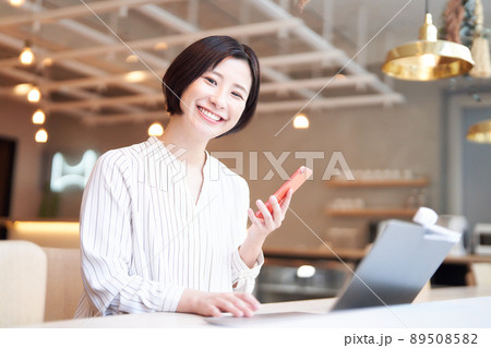 カフェでスマホを使う笑顔の若い女性 89508582