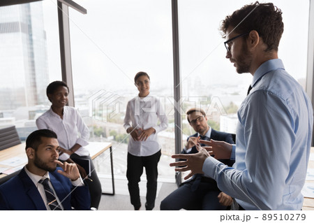 Serious young coach training diverse young business team 89510279