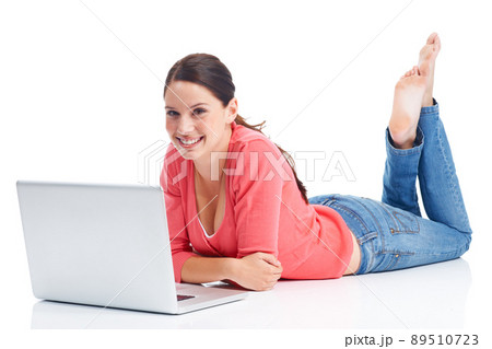 Relaxing just how she likes it. Happy young woman relaxing while using her laptop. Relaxing just how she likes it. Happy young woman relaxing while using her laptop. 89510723