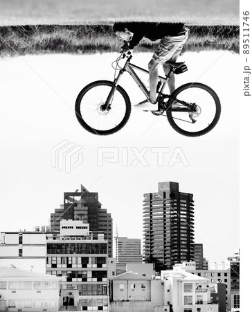 The sky is the limit. A man on a bicycle hovers in the air over the rooftops of a city - perception. 89511746