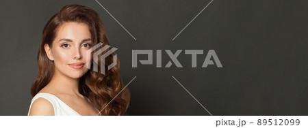Beautiful young woman with healthy glowy skin and long hair over gray wall background. 89512099