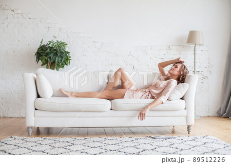 Beautiful woman resting on sofa at home Beautiful woman resting on sofa at home 89512226