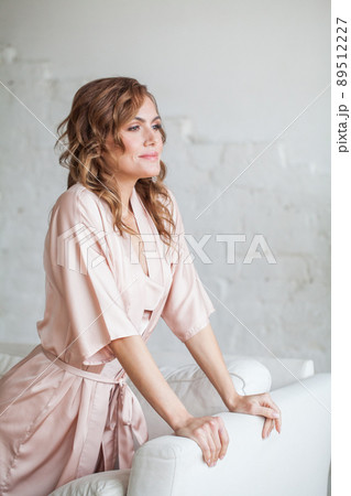Smiling young beautiful blonde woman wearing silky home clothes Smiling young beautiful blonde woman wearing silky home clothes 89512227