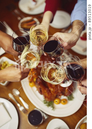 Tis the season to be jolly. Closeup shot of a group of people making a toast at a dining table. 89513019