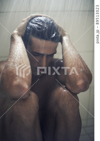 Depression is getting him down. A depressed man sitting in the shower. 89513023