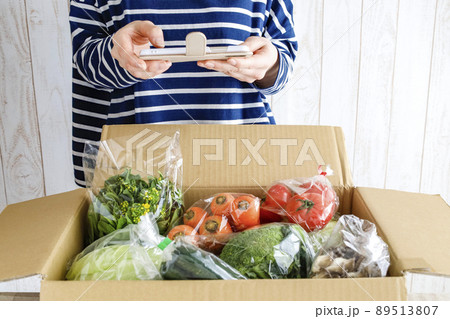 箱いっぱいの野菜を開封する女性 89513807