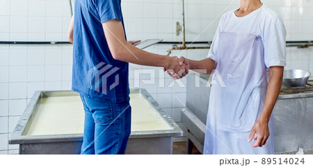 Im glad to be a part of this. Cropped shot of two people shaking hands in a cheese factory. 89514024