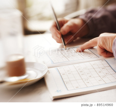 Woman trying to solve Sudoku Puzzle - window, sunlight, and coffee. Woman trying to solve Sudoku Puzzle - window, sunlight, and coffee. Woman trying to solve Sudoku Puzzle - window, sunlight, and coffee. Woman trying to solve Sudoku Puzzle - window, sunlight, and coffee. 89514960