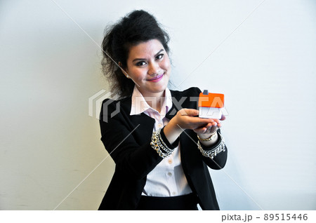 Business woman hold house toy model on white background 89515446