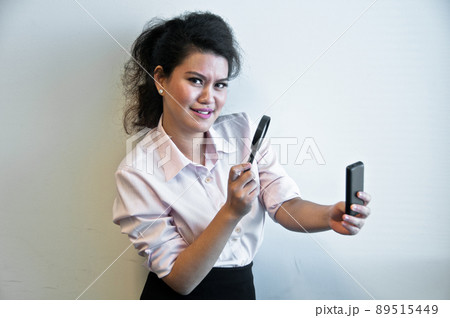 Business woman examine mobile phone by magnifier Business woman examine mobile phone by magnifier 89515449