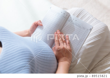 母子手帳を見ている妊婦 母子手帳を見ている妊婦 89515821