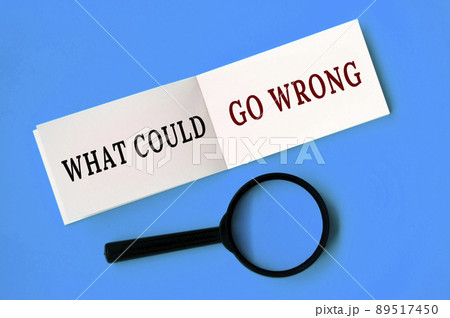 What could go wrong text on notepad with magnifying glass on blue background. Conceptual What could go wrong text on notepad with magnifying glass on blue background. Conceptual 89517450