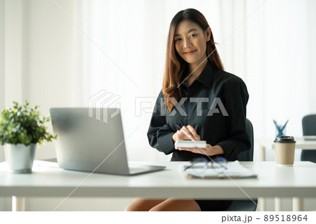 Portrait young Asian accountant enjoys working on computers and calculators in the office. Portrait young Asian accountant enjoys working on computers and calculators in the office. 89518964
