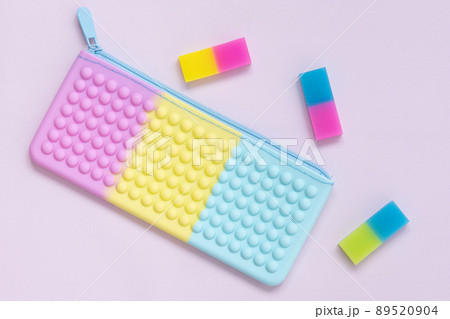 Beautiful combination of pastel shades. Purple, pink, yellow and blue. Top view of a children's pencil case and erasers Beautiful combination of pastel shades. Purple, pink, yellow and blue. Top view of a children's pencil case and erasers 89520904