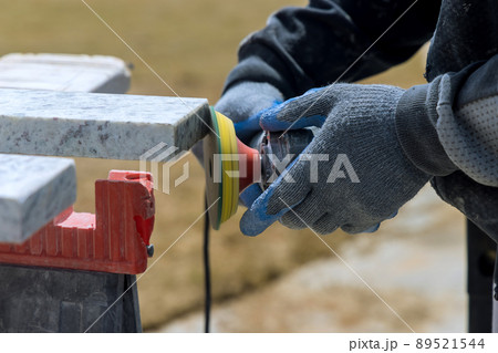 The master works with a granite stone using a grinder 89521544