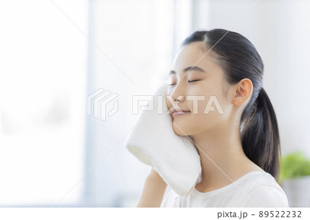 タオルで顔を拭く若い女性 89522232