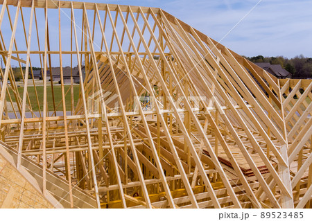 View of roof truss system beams wooden frame house under construction 89523485