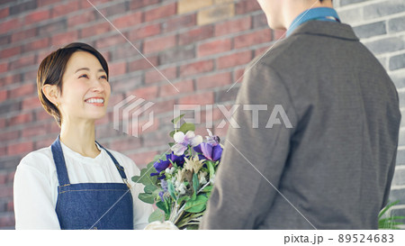 花束を渡す女性　花屋の店員　フラワーアレンジメント 89524683