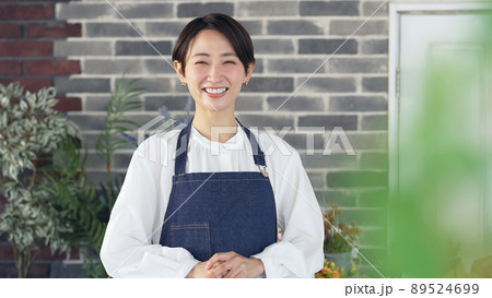 出迎えるエプロンをつけた女性 店員 接客 出迎えるエプロンをつけた女性 店員 接客 89524699