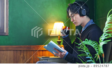 暗い部屋で本を読む男性 89524787