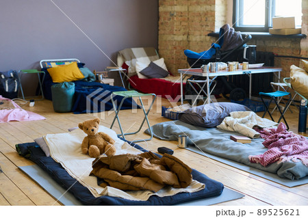 Part of spacious room with sleeping places on wooden floor for refugees 89525621