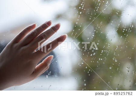 雨粒の窓に置かれた女性の手　Female hands 89525762