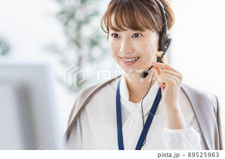 パソコンの前でヘッドセットをつけて通話をしているビジネスウーマン パソコンの前でヘッドセットをつけて通話をしているビジネスウーマン 89525963
