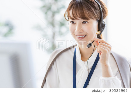 パソコンの前でヘッドセットをつけて通話をしているビジネスウーマン パソコンの前でヘッドセットをつけて通話をしているビジネスウーマン 89525965