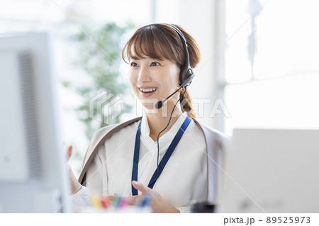 パソコンの前でヘッドセットをつけて通話をしているビジネスウーマン パソコンの前でヘッドセットをつけて通話をしているビジネスウーマン 89525973