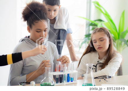 Young teacher teaching group student about science and test chemical for liquid in the lab of school 89528849