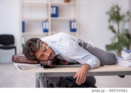 Young male employee in oversleeping concept 89534081