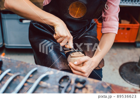 Shoemaker working on the frame of a shoe 89536623
