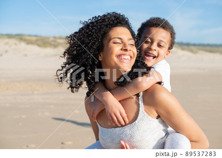 Contented mother and son spending time on beach Contented mother and son spending time on beach 89537283