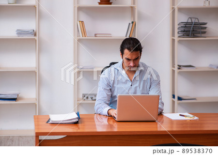 Young male employee sitting in the office 89538370