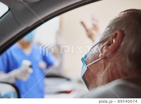 Thank you for the swift service. Shot of a senior man waving at a healthcare worker while in his car at a drive through vaccination site. Thank you for the swift service. Shot of a senior man waving at a healthcare worker while in his car at a drive through vaccination site. 89540074