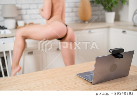 A girl in underwear flirts on an online video connection on a laptop. Woman working as a web cam model A girl in underwear flirts on an online video connection on a laptop. Woman working as a web cam model 89540292