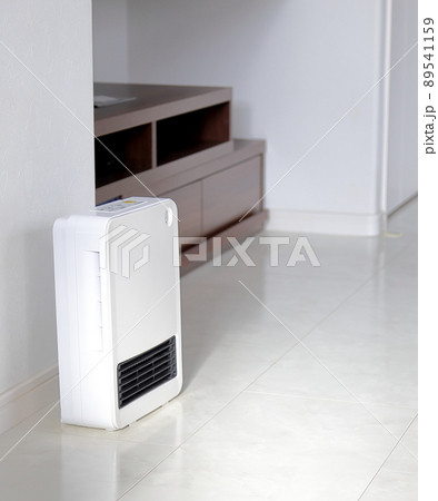 薄暗いリビングに置かれた白い電気ヒーター 89541159